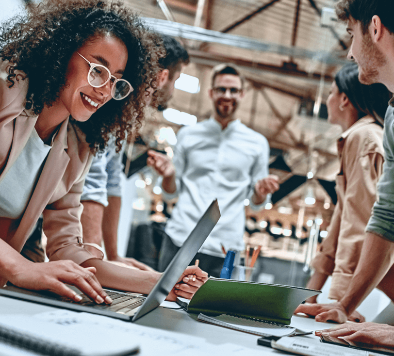 Grupo de pessoas em reunião num ambiente de trabalho sorrindo